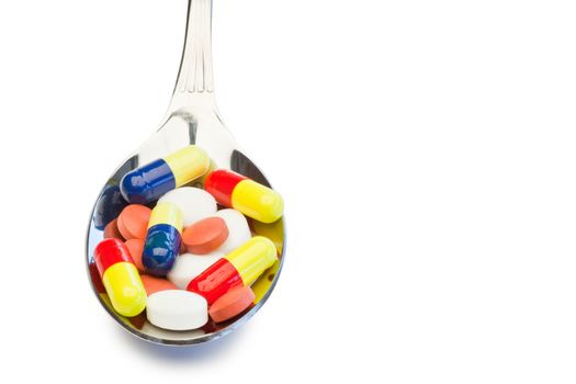 Spoon full of color medicine on a white background