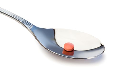 Pill in a spoon on a white background