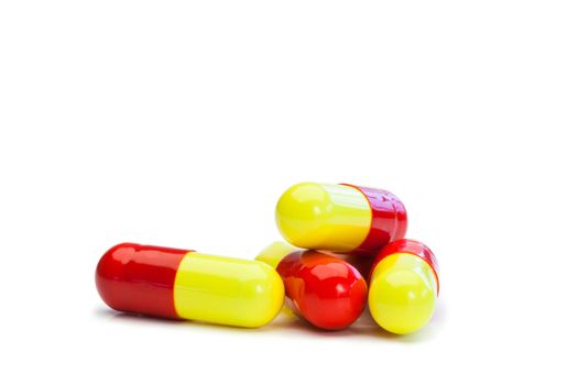 Yellow and red pills on a white background