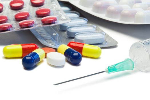 Pills and serynge on a white background