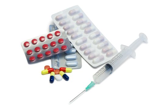 Pills with blister strips and serynge on a white background