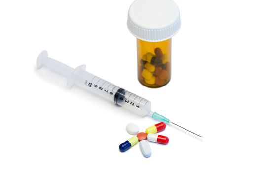 Color pills with box pills and serynge on a white background