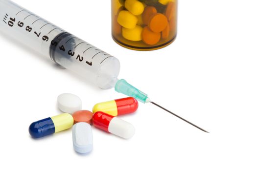 Pills with medicine box and serynge on a white background