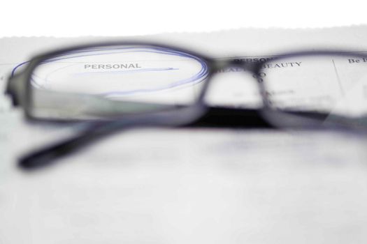 Newspapers and black glasses on a white a background