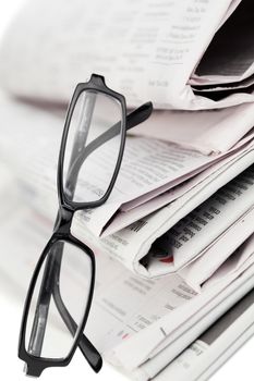 Newspapers and black glasses on a white a background