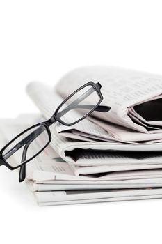 Newspapers and black glasses on a white a background
