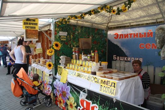 Customers are testing and buying honey at the market, Moscow, Russia