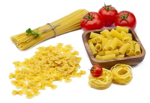 Uncooked noodles and tomatoes used to make a pasta dish on a white background.