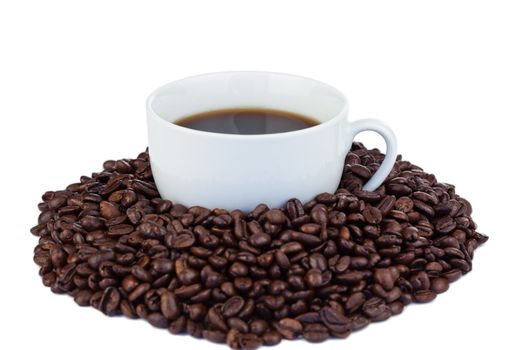 Small cup of coffee and coffee beans on a white background
