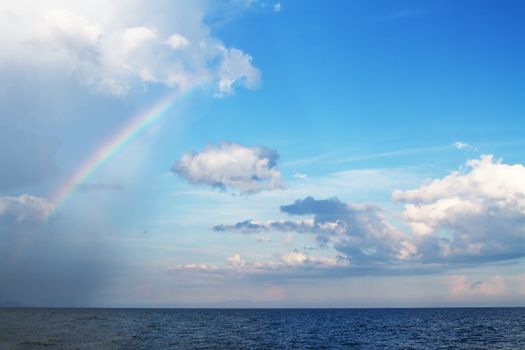 Rain over the sea with a beautiful rainbow