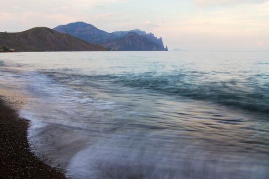 Beautiful seascape with dramatic clouds and mountains on background