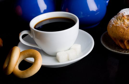 Coffee with pastry on black background