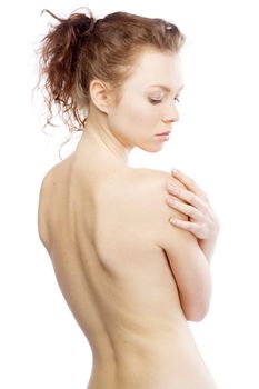 Beautiful red-haired woman showing her back, isolated on white background