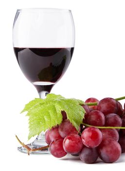 Glass of red wine with grapes on foreground