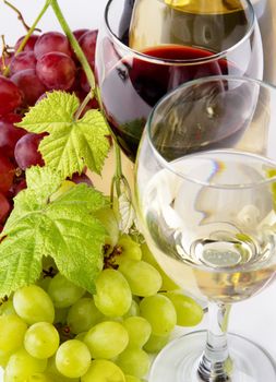 Red and white wine, with bunches of grapes, closeup photo