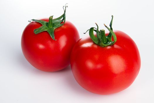 Two tomatoes on gray bacground, studio photo