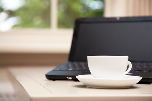 Laptop and a cup of coffee on a table