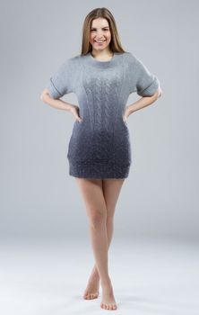 Beautiful elegant model in woolen sweater on gray background 