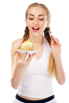 Young lady tasting a cake, studio portrait