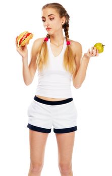 Young woman holding a hamburger and an apple, white background