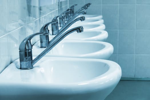 Row of wash sinks in public bathroom