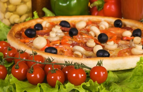 Closeup picture of a pizza with vegetables and cherry tomato