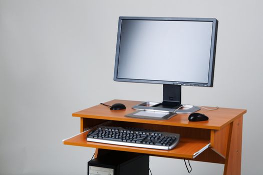 Modern personal computer on a table, on neutral background