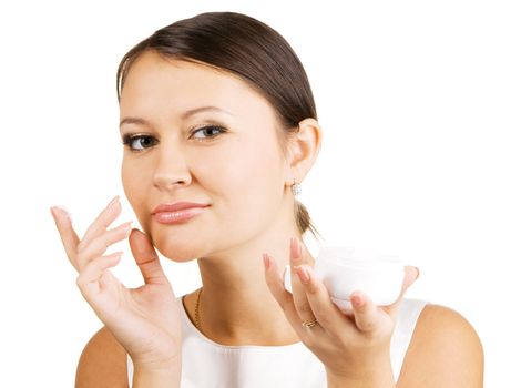 Young beautiful woman applying skin cream, isolated on white background