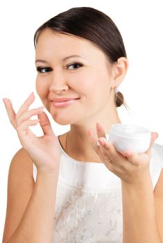 Young beautiful woman applying skin cream, isolated on white background