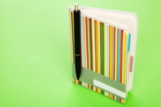 Colorful notepad on green background