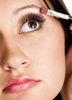 Beautiful young woman applying makeup, closeup photo