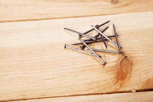 Nails on raw pine planks background