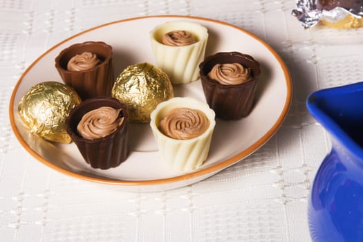 Chocolate candies of dark and white milk chocolate on a plate