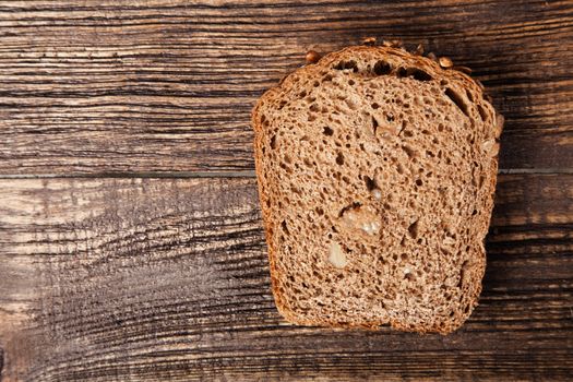 Slice of brown bread on a wooden table