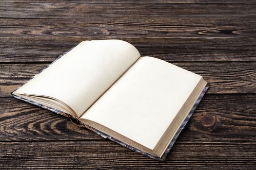 Aged blank book on wooden table, blank pages