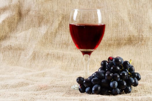 Red wine and grapes on vintage background, studio photo