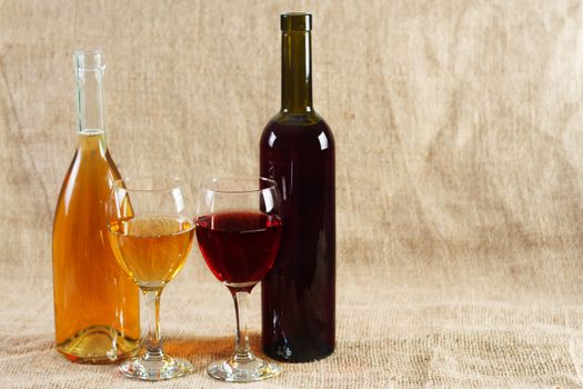 Wine glasses and bottles on vintage background, studio photo