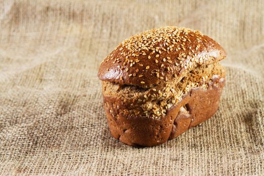 Loaf of brown bread, studio photo on cloth background