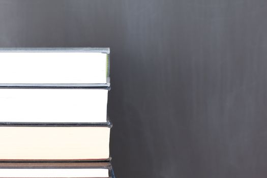 Stack of books and a clean blackboard