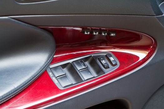 Control knobs in a luxury car, in mahogany finish