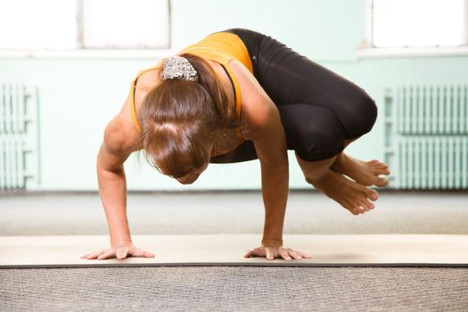 Mature woman exercising yoga in a gym