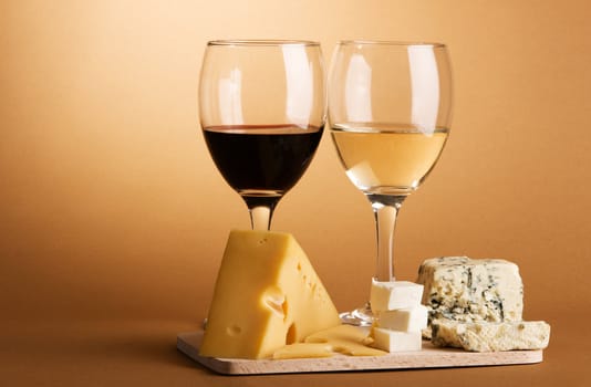 Wine and cheese over brown background still-life photo