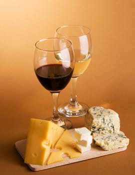 Wine and cheese over brown background still-life photo
