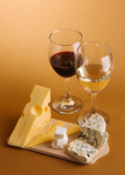 Wine and cheese over brown background still-life photo