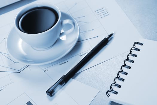 Worktable covered with documents, with a cup of coffee