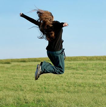 Girl jumping on a green field