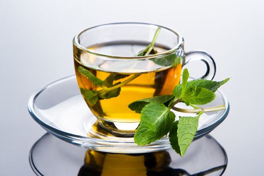 Tea cup with fresh mint leaves, closeup photo