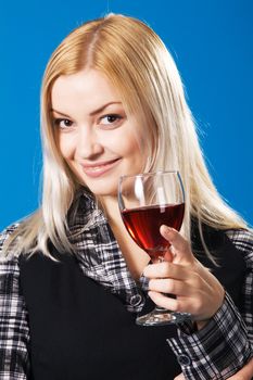 Young woman with a glass of red wine, blue background