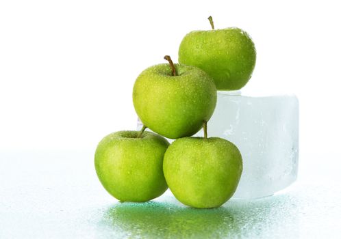 Green apples on ice cube, studio still life