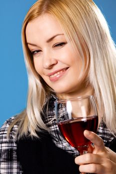 Young woman with a glass of red wine, blue background